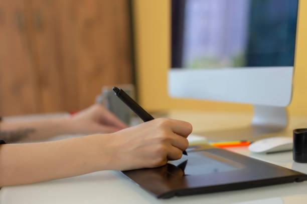 istock Close-up of a female graphic designer or photographer working on computer using digital tablet at office. 1149221727