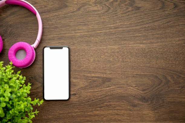 istock touch phone with isolated screen on wooden table with headphones 1149222895