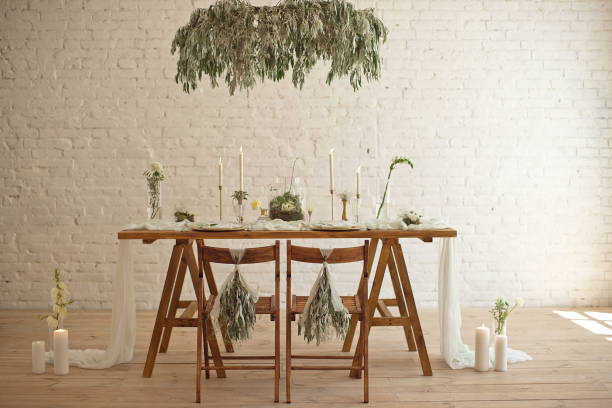 istock Boho wedding table setting, rustic decorations, gold and blue details, wooden table, bokeh. Luxury wedding decor. Monstera leaves and orchid flowers 1149223757