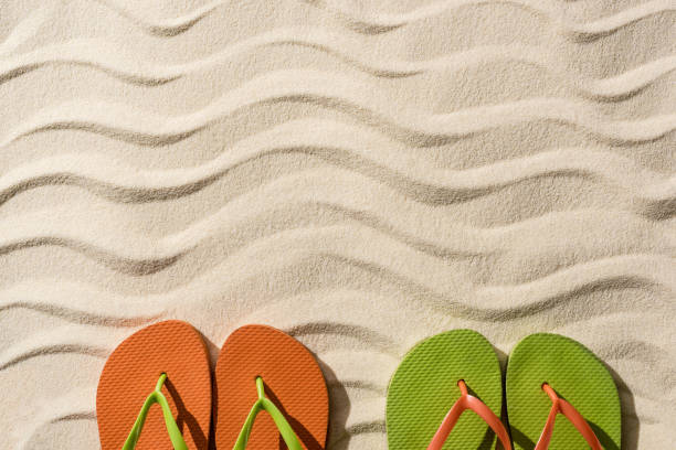 istock top view of colorful flip flops on wavy sand with copy space 1149225505