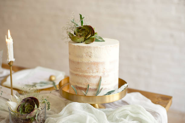 Elegant white wedding cake with flowers and succulents in boho style. Rustic Wedding Cake.
