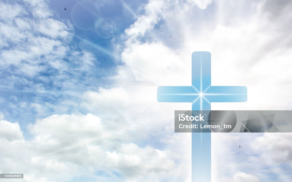 Crucifix cross on beautiful sky with sunbeam. Holy cross of Jesus christ on clouds background. Backgrounds Stock Photo