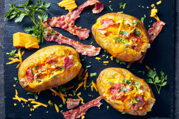 istock freshly Baked hot Potatoes loaded with crispy fried Bacon, pulled chicken breast and melted cheddar cheese 1149229223