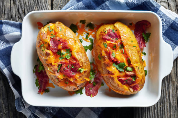 istock freshly Baked hot Potatoes loaded with crispy fried Bacon, pulled chicken breast and melted cheddar cheese 1149229241