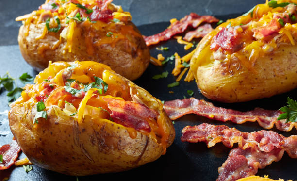 istock freshly Baked hot Potatoes loaded with crispy fried Bacon, pulled chicken breast and melted cheddar cheese 1149229285