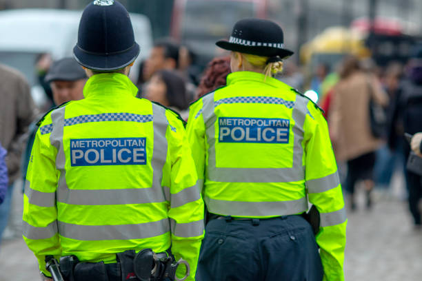 Metropolitan policeman and Policewoman in High Vis jackets looking at crowds in Westminster, central London 3rd May, 2019 - Metropolitan policeman and Policewoman in High Vis jackets looking at crowds in Westminster, central London metropolitan police stock pictures, royalty-free photos & images