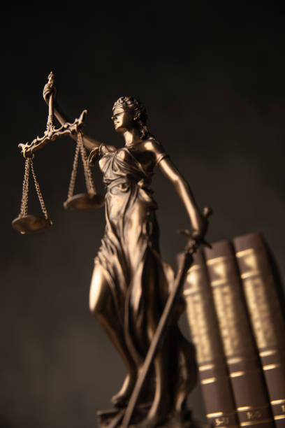 justice goddess statue with law books in the back