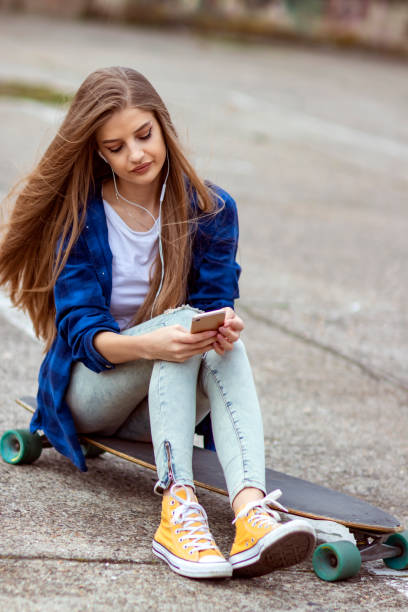 istock Female Skateboarder is Using a Mobile Phone in the Street 1149233397