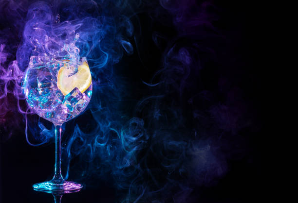 splashing gin tonic in a smoky background gin tonic cocktail splashing in blue and purple smoky background tequila drink photos stock pictures, royalty-free photos & images
