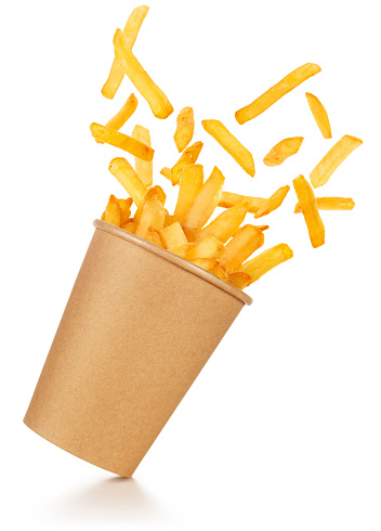 fries spilling out of a take-out paper cup tilted on white background