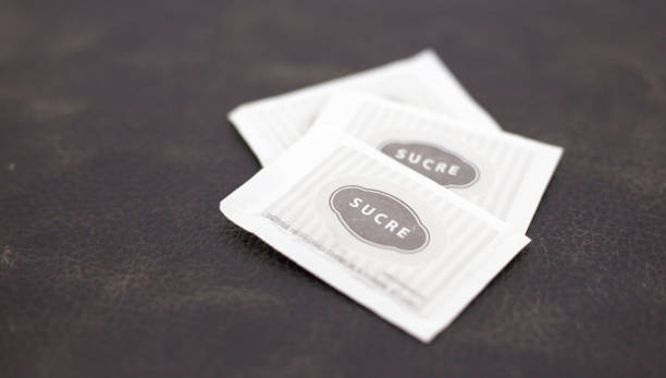 istock Small Paper Sugar Packet Isolated on wooden Background. 1149236449