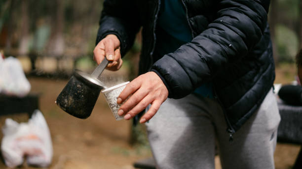 istock Man putting hot water into cardboard cup at camp 1149237696