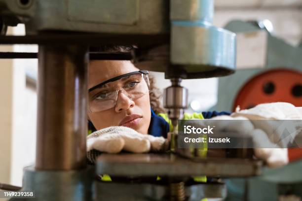 Female Apprentice Using Yoke Machine In Factory Stock Photo - Download Image Now - Manufacturing, Occupation, Engineer