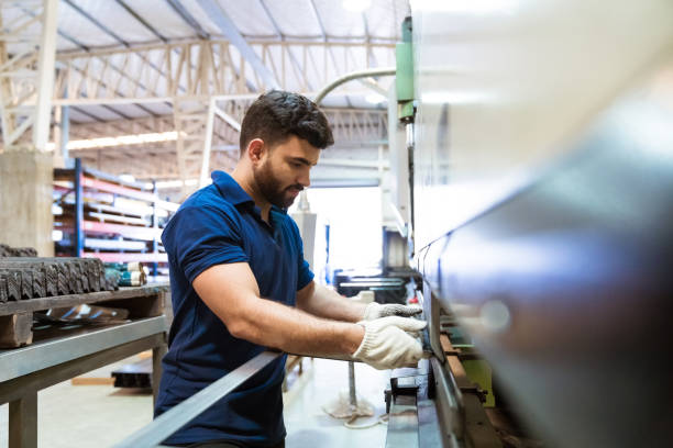 инженер-мужчина, использующий тяганую машину на заводе - trainee factory machinist manual worker стоковые фото и изображения