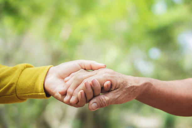 istock young and old woman hand holding each other ,helping hand concept 1149241373