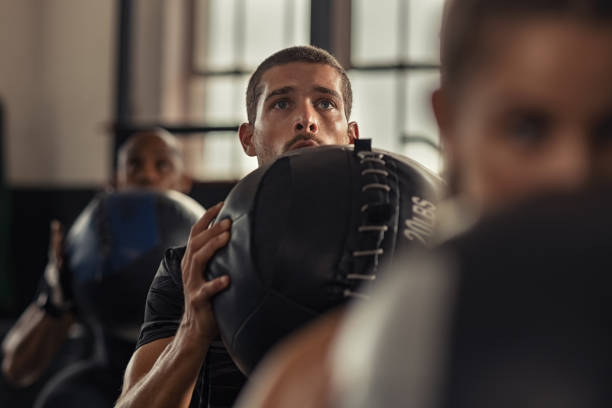 Fitness man doing squat with heavy ball