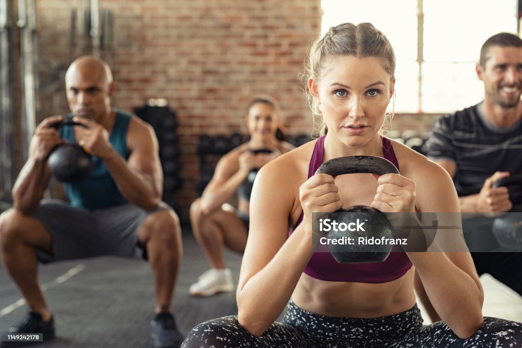 Fitness-Frau hocken mit Wasserkocher Glocke - Lizenzfrei Fitnesstraining Stock-Foto