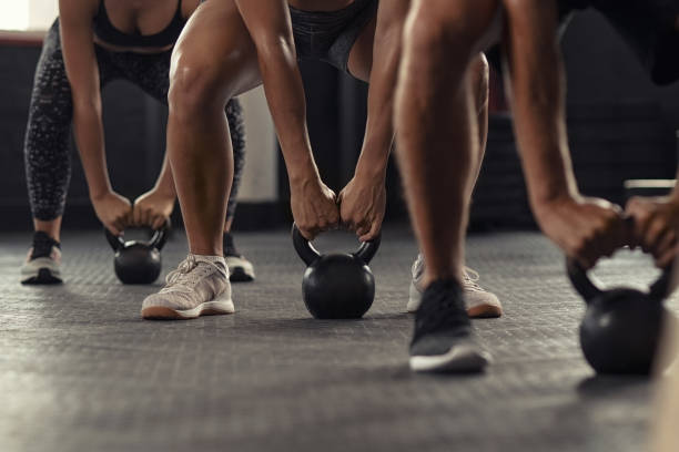 fitness people hands lifting kettle bell - color intensity fotos imagens e fotografias de stock