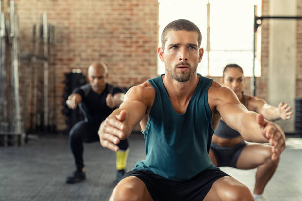 uomo fitness accovacciato con lezione in palestra - crouching foto e immagini stock