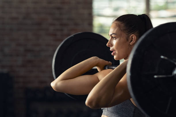 donna che fa sollevamento pesi in palestra - gym barbell weights exercising foto e immagini stock