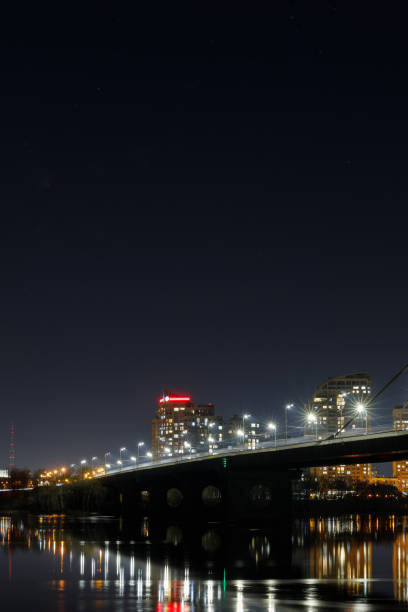 istock dark cityscape with illuminated buildings, lights, bridge and river 1149242958