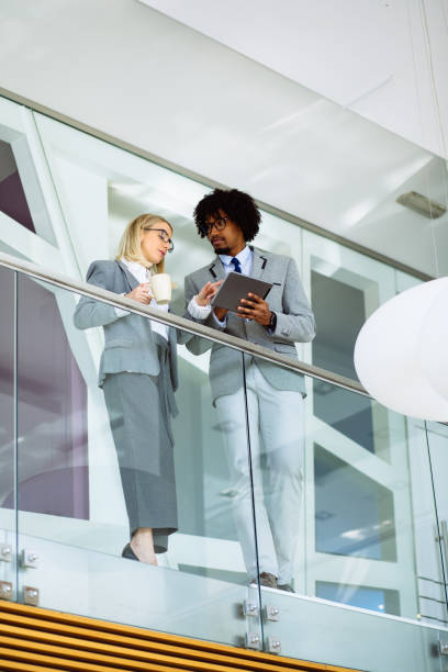 istock Business colleagues working on digital tablet in office hallway 1149242979