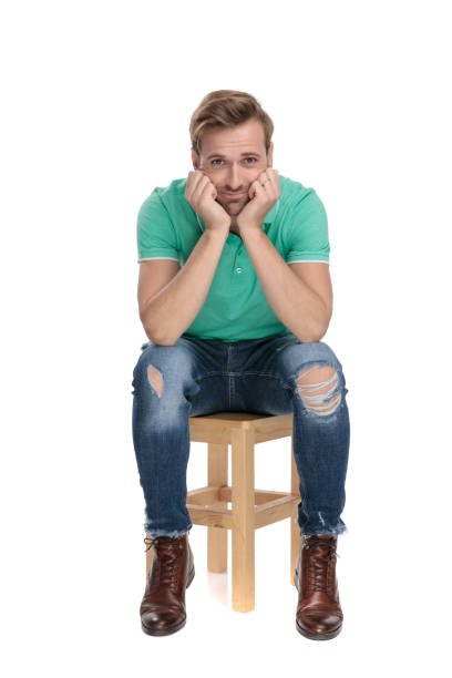 istock seated  cute man being childish with hands at face 1149244149