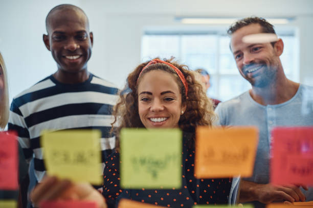 istock Smiling designers brainstorming together with sticky notes in an office 1149244249