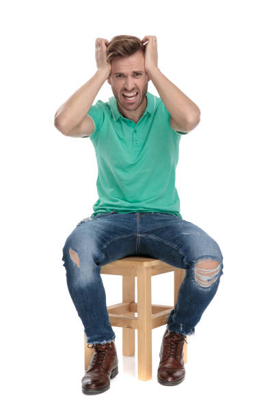 istock seated upset man yell with hands at head 1149245911