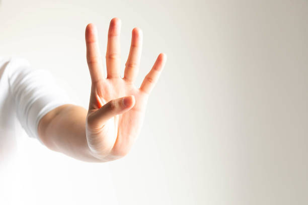istock A hand showing number four in close-up on white background and little light. 1149246512