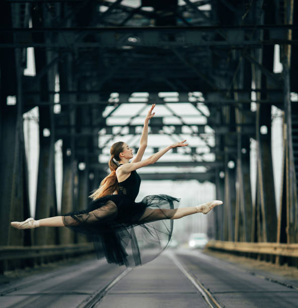 ballerina che salta in twine posa su strada e rotaie. - ballet dancer ballet dancer the splits foto e immagini stock