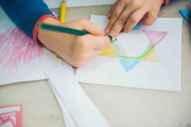 istock Learning materials in a montessori methodology school. Geometric materials. Little girls drawing on paper. 1149254220