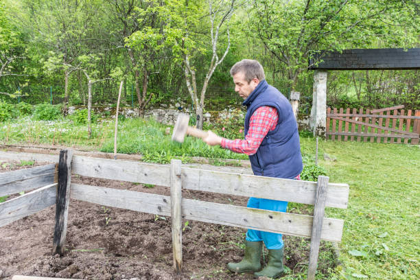 istock Man Mending Wooden Fence using Hammer 1149255659