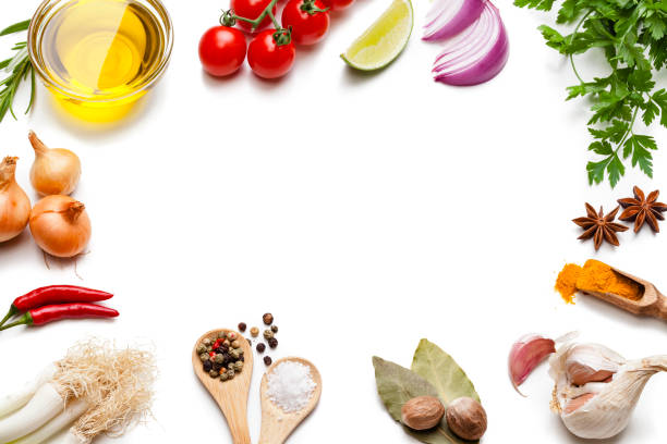 Cooking and seasoning backgrounds: vegetables, herbs and spices frame. Cooking and seasoning backgrounds: High angle view of a white background with multi colored vegetables, herbs and spices placed all around the border making a frame and leaving a useful copy space for text and/or logo at the center. The composition includes olive oil, cherry tomatoes, lime slice, red onion, parsley, star anise, curry powder, garlic, bay leaves, nutmeg, salt, pepper, chili pepper, and gold onions. High key DSRL studio photo taken with Canon EOS 5D Mk II and Canon EF 100mm f/2.8L Macro IS USM. cooking with garlic stock pictures, royalty-free photos & images