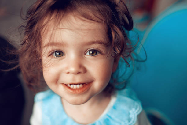 so cute and innocent smile portrait of adorable baby girl looking at camera and enjoying playing. only baby girls stock pictures, royalty-free photos & images