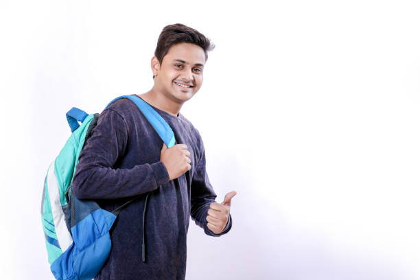 バッグを持つインドの大学少年 - thumbs up book smiling student ストックフォトと画像