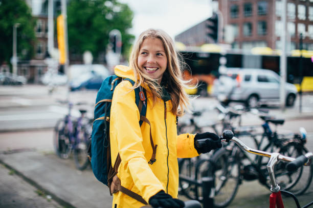 holländerin mit fahrrad - regenmantel stock-fotos und bilder