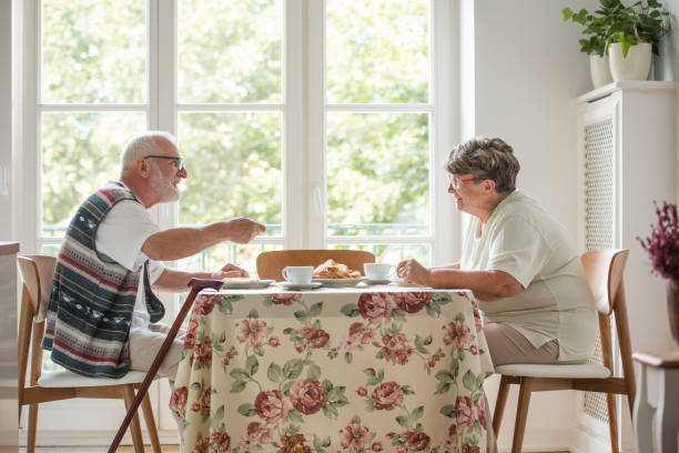 istock Senior couple sitting together at table drinking tea and eating cake 1149259683