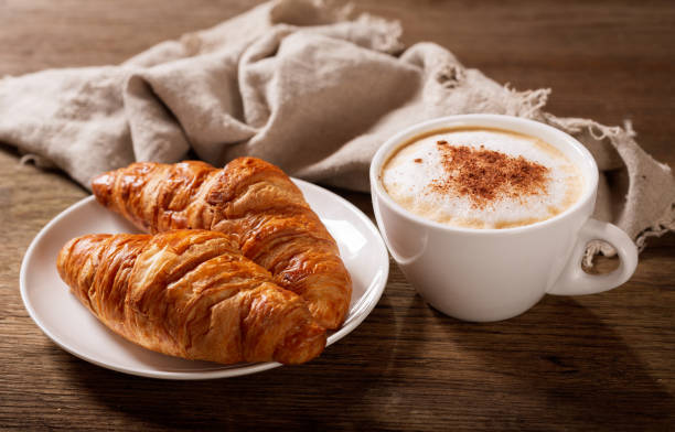 istock cup of cappuccino coffee and croissants 1149259723
