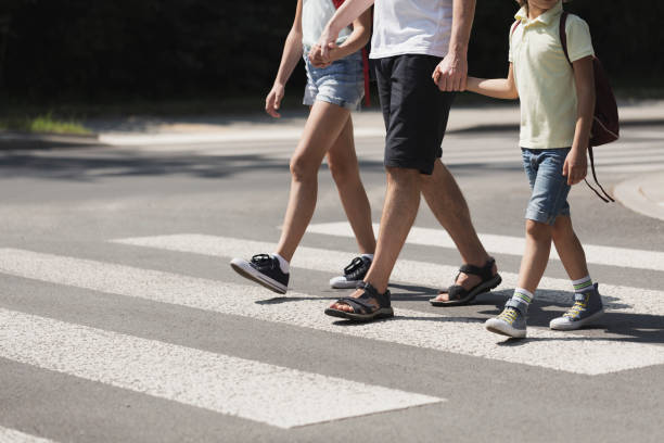 istock Father holding hands with his kids while on pedestrian crossing 1149260013