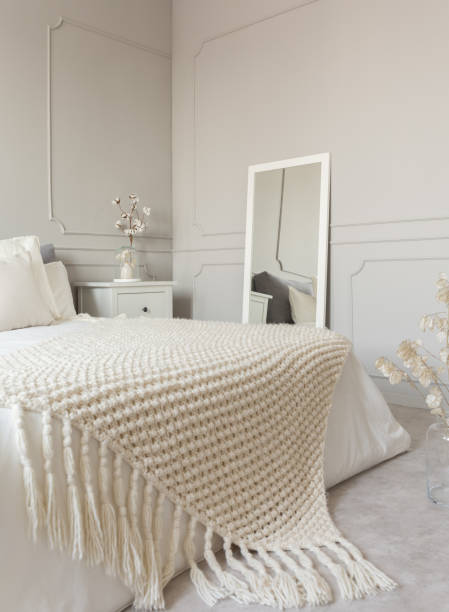 istock Cozy cream colored woolen blanket on king size bed in bright bedroom 1149261289