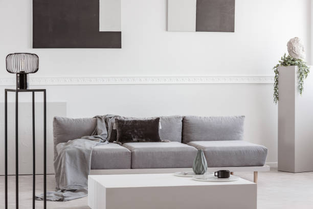 istock Grey blanket and black pillow on comfortable sofa in stylish living room interior 1149263340