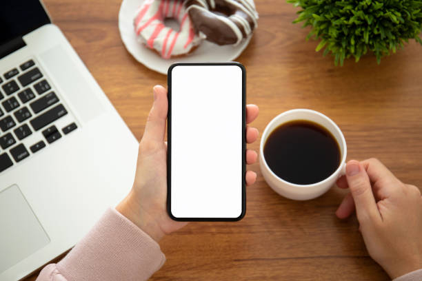 istock female hands holding phone with isolated screen in the office 1149265895