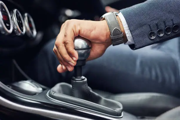 Cropped shot of an unrecognizable man's hand on his gearstick while driving