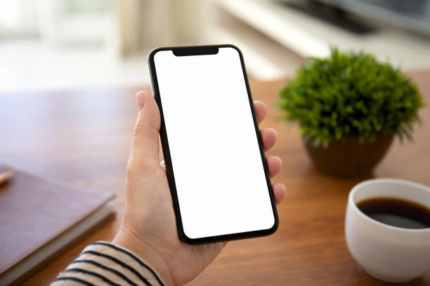 istock female hands holding touch phone with isolated screen in office 1149267462