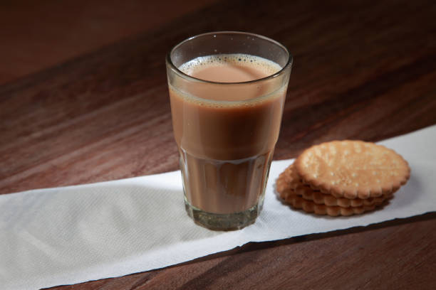 istock A glass of tea and biscuits on a wooden table. 1149267542