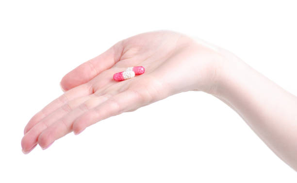 istock Pink white capsules medicine pharmasy in hand 1149272155