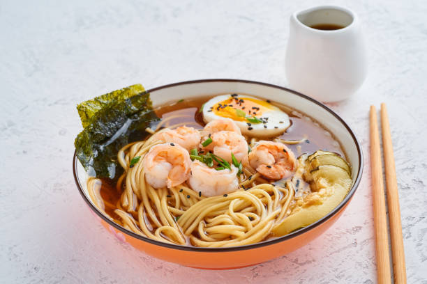 istock Asian soup with noodles, ramen with shrimps, miso paste, soy sauce. White stone table, side view 1149273826