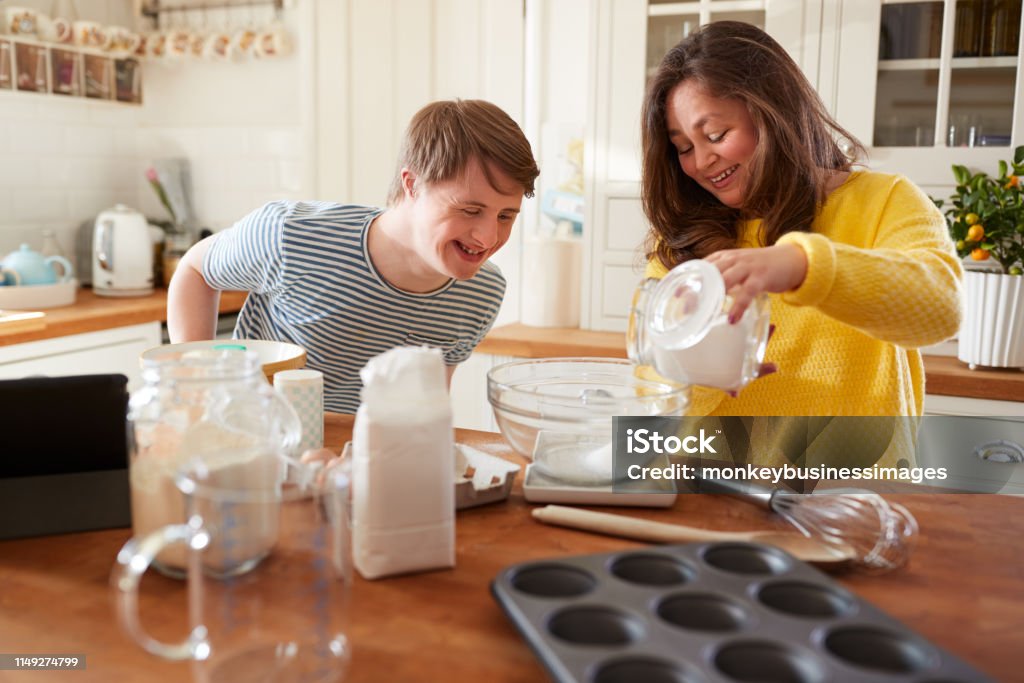 Young Downs Syndrome Couple Baking In Kitchen At Home Disability Stock Photo