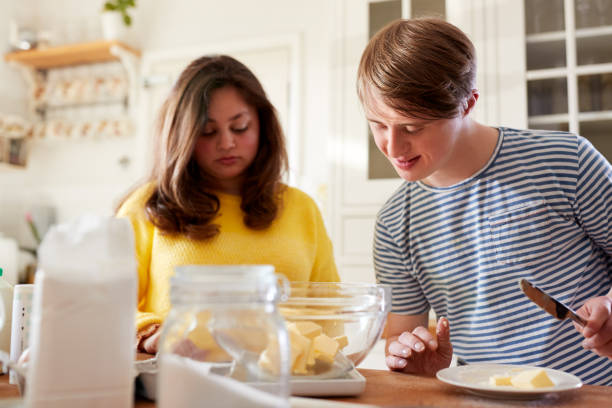istock Young Downs Syndrome Couple Baking In Kitchen At Home 1149275057